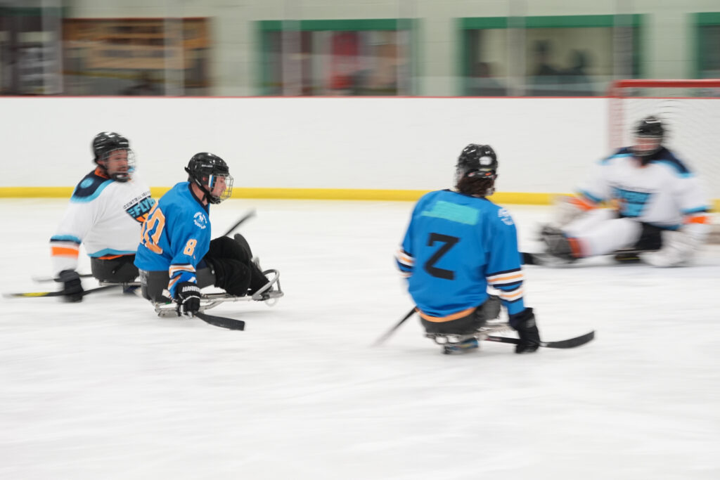 A group of athletes competing field hockey with helmet