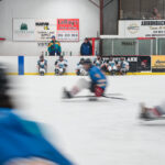 A group of athletes skating with helmet on the rink