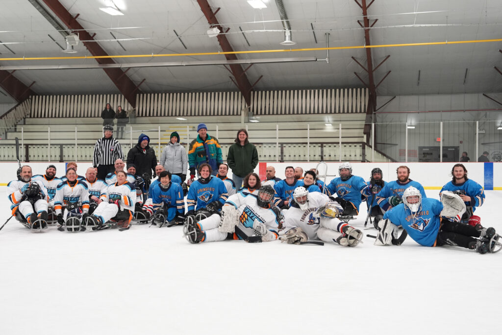 A group of athletes competing field hockey with helmet