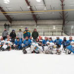 A group of athletes competing field hockey with helmet