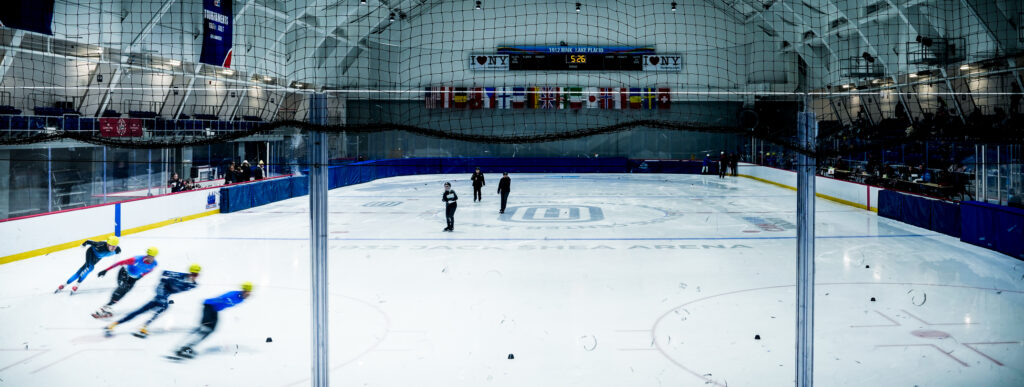 A group of athletes skating with helmet on the rink