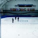 A group of athletes skating with helmet on the rink