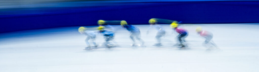 A group of athletes skating with helmet on the rink