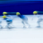 A group of athletes skating with helmet on the rink
