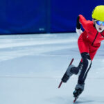 An athlete skating with helmet on the rink
