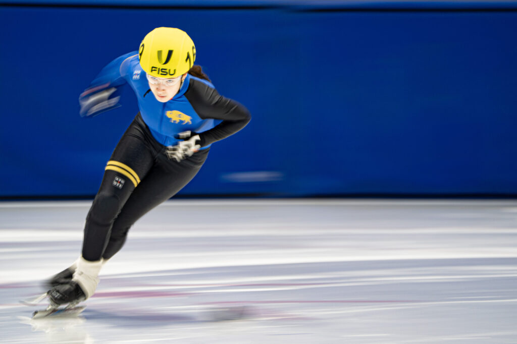 An athlete skating with helmet on the rink