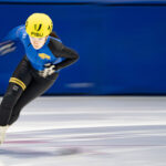 An athlete skating with helmet on the rink