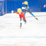 A group of athletes skating with helmet on the rink