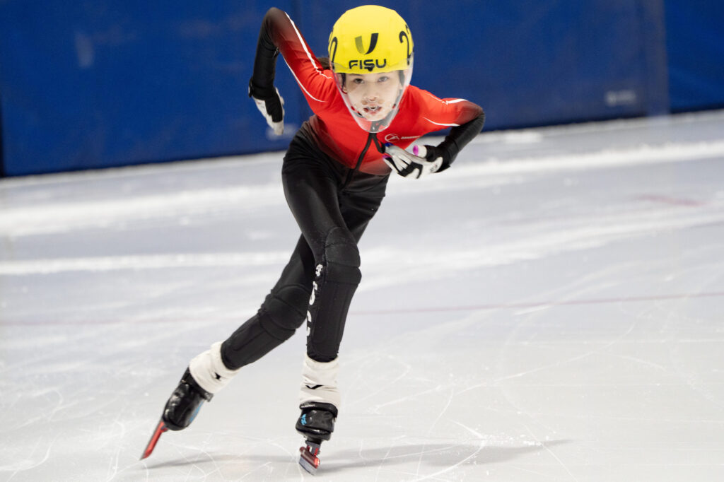 An athlete skating with helmet on the rink