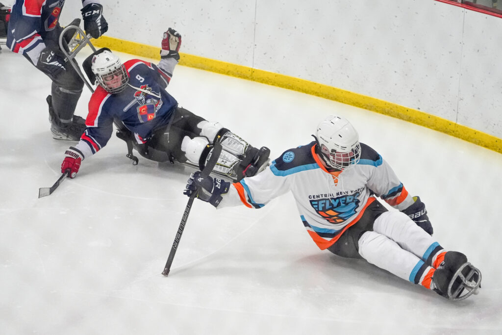 A group of athletes competing field hockey with helmet