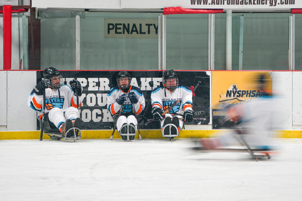 A group of athletes competing field hockey with helmet
