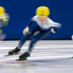 A group of athletes skating with helmet on the rink