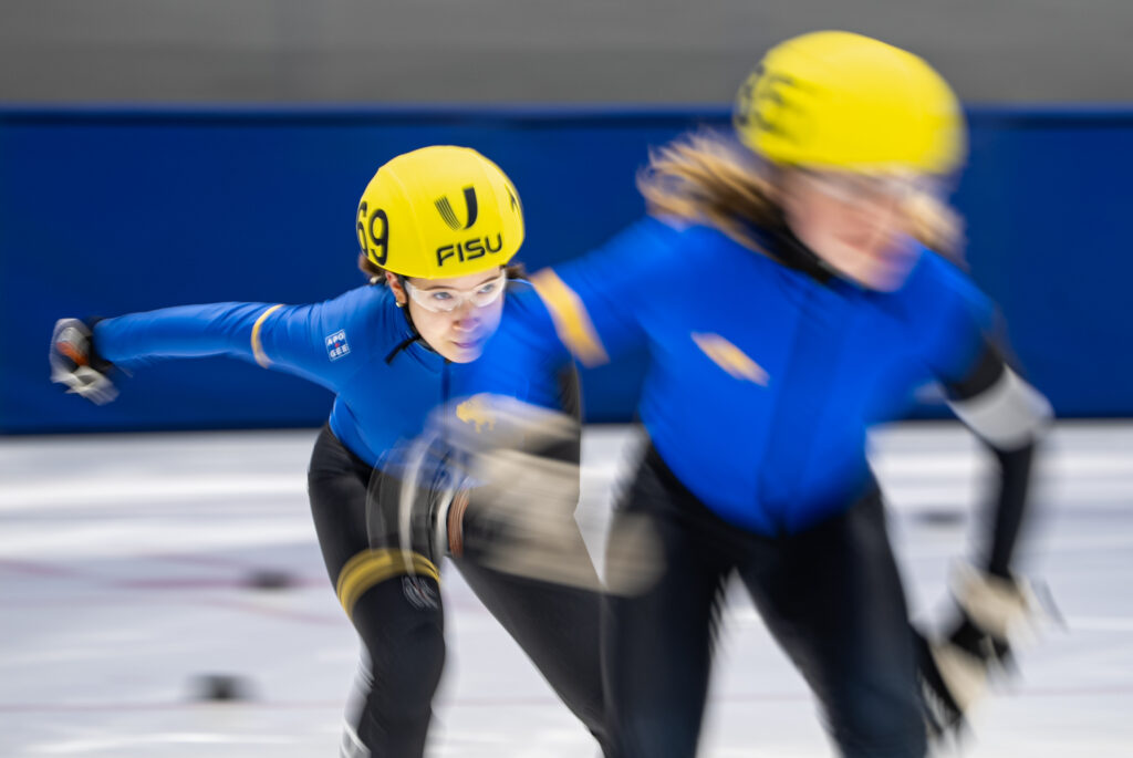 Two athletes skating with helmet on the rink
