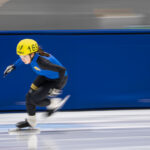 An athlete skating with helmet on the rink