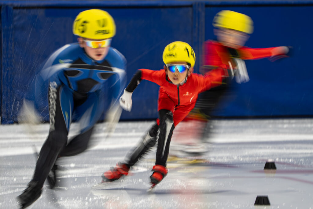 A group of athletes skating with helmet on the rink
