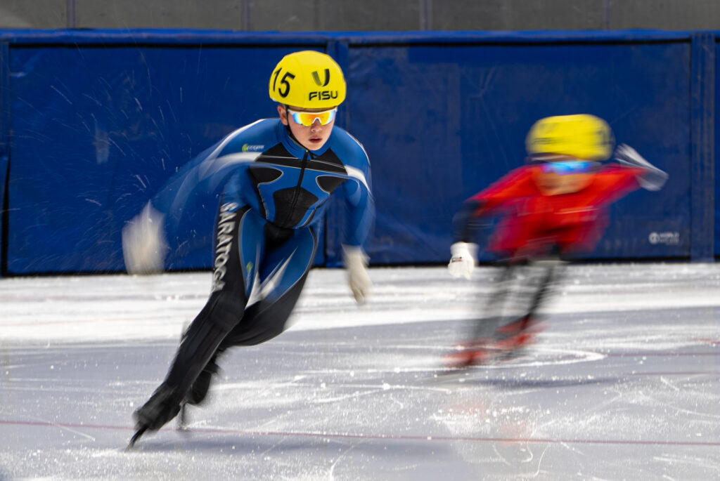 Two athletes skating with helmet on the rink
