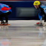 Two athletes skating with helmet on the rink