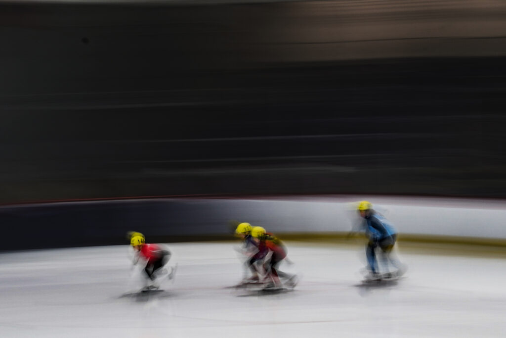 A group of athletes skating with helmet on the rink