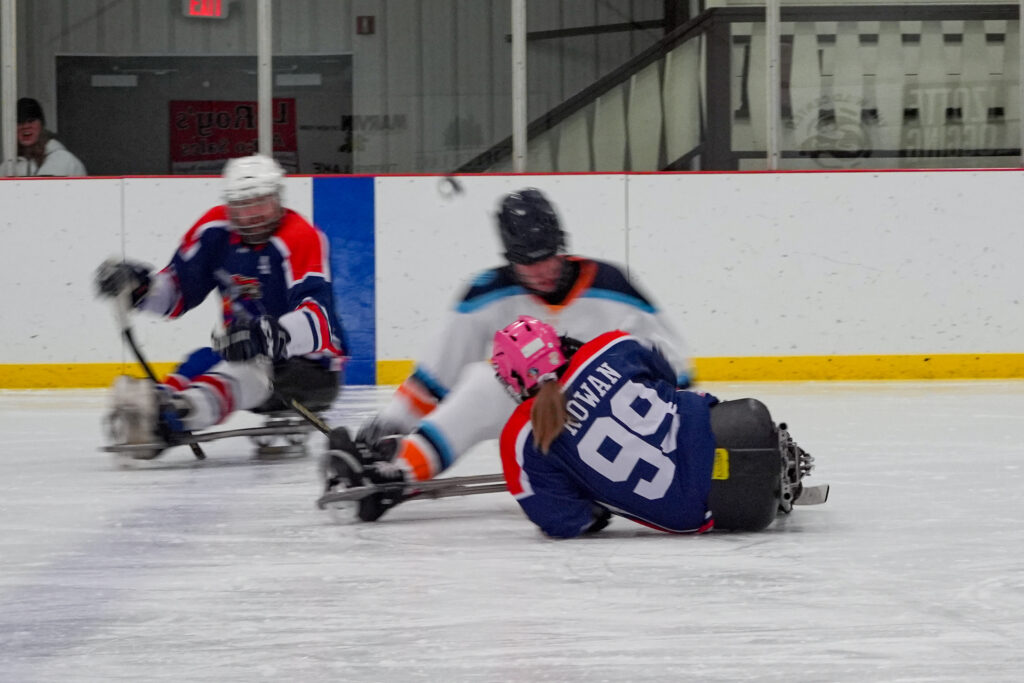 A group of athletes competing field hockey with helmet