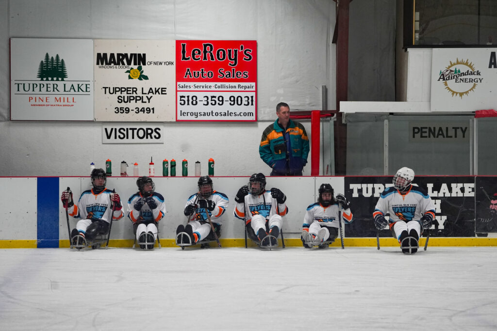 A group of athletes competing field hockey with helmet
