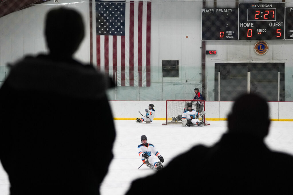 A group of athletes competing field hockey with helmet