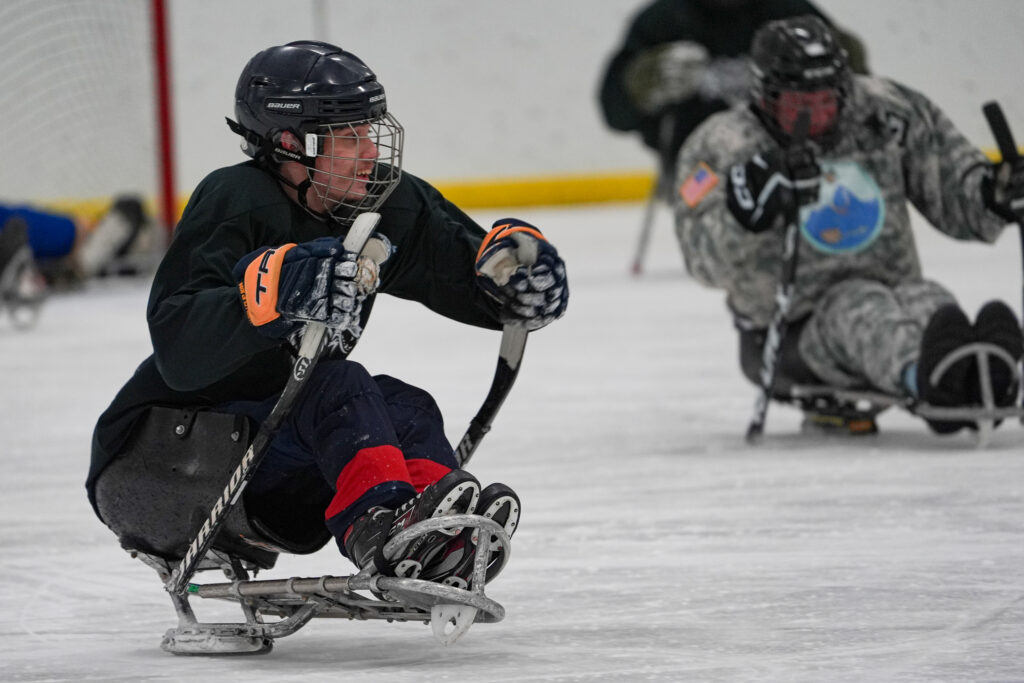 A group of athletes competing field hockey with helmet