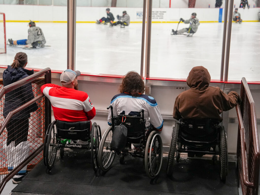 A group of athletes competing field hockey with helmet
