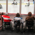A group of athletes competing field hockey with helmet