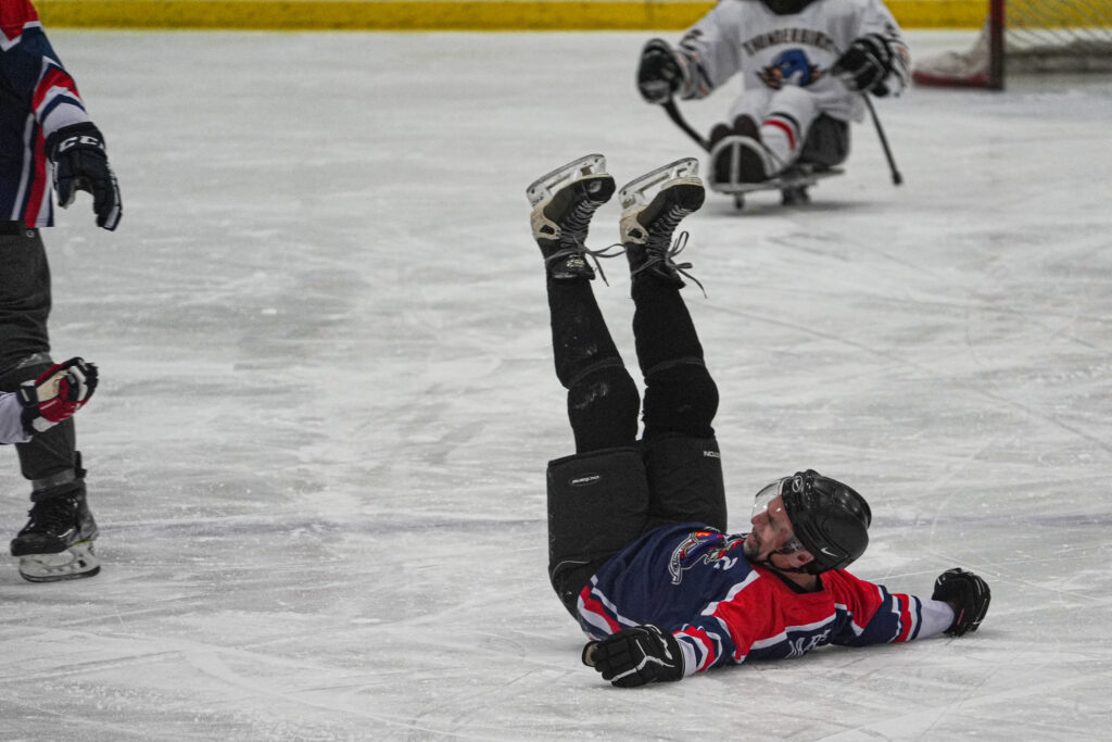 A group of athletes competing field hockey with helmet