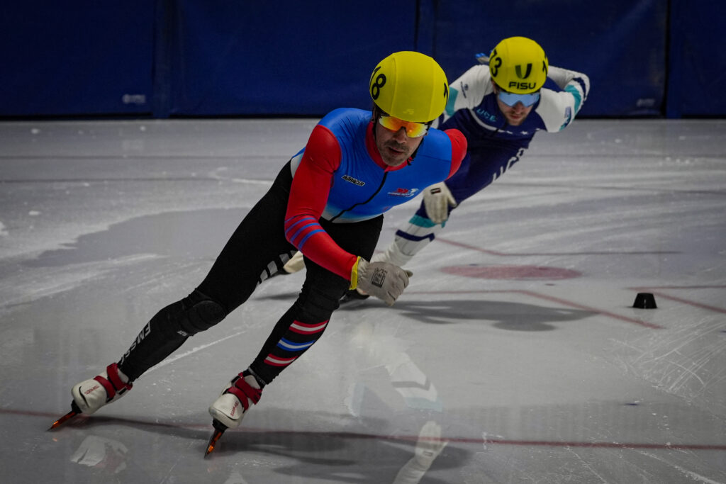 Two athletes skating with helmet on the rink