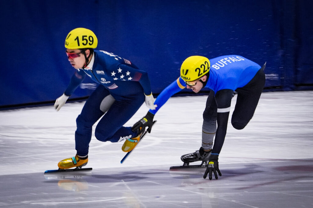 Two athletes skating with helmet on the rink