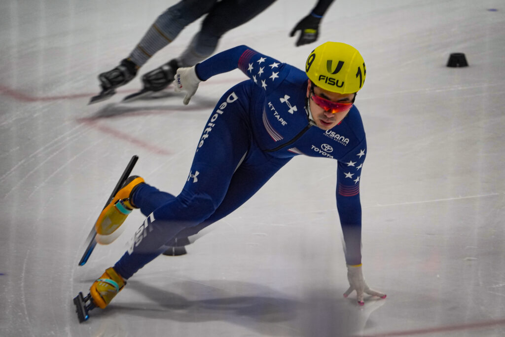Two athletes skating with helmet on the rink