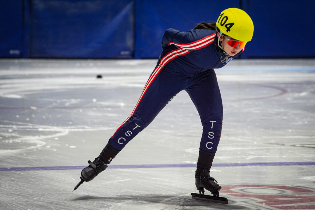 An athlete skating with helmet on the rink