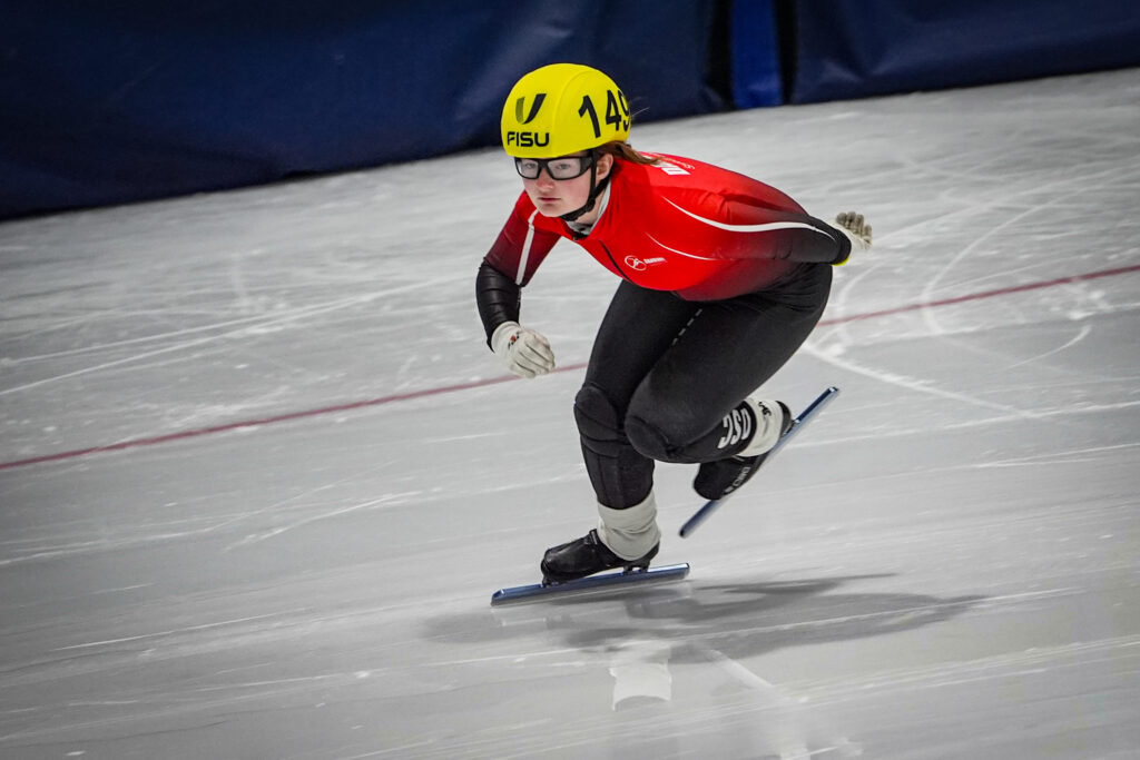 An athlete competing field hockey with helmet