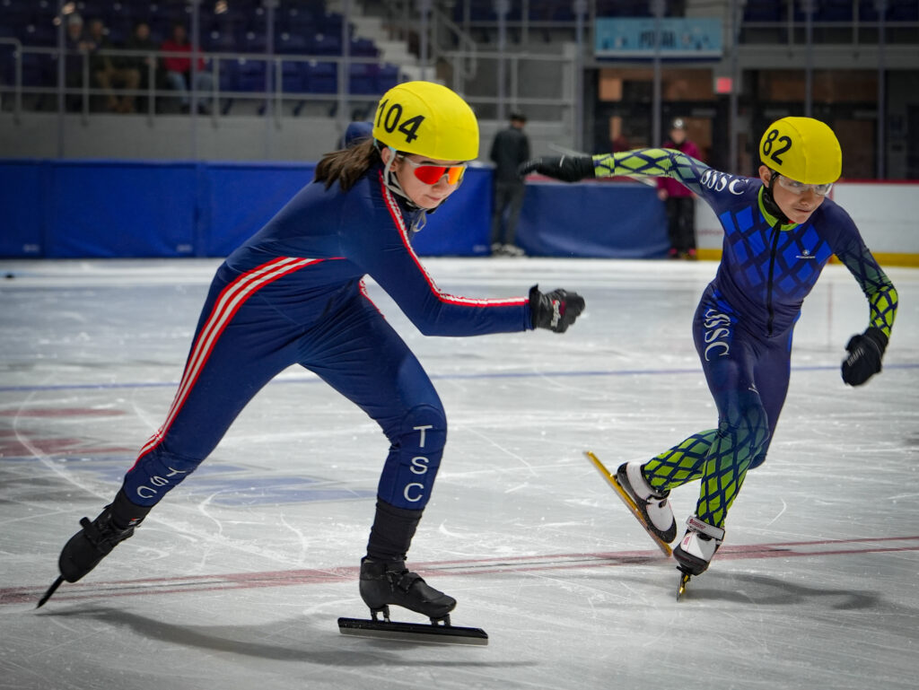 A group of athletes skating with helmet on the rink