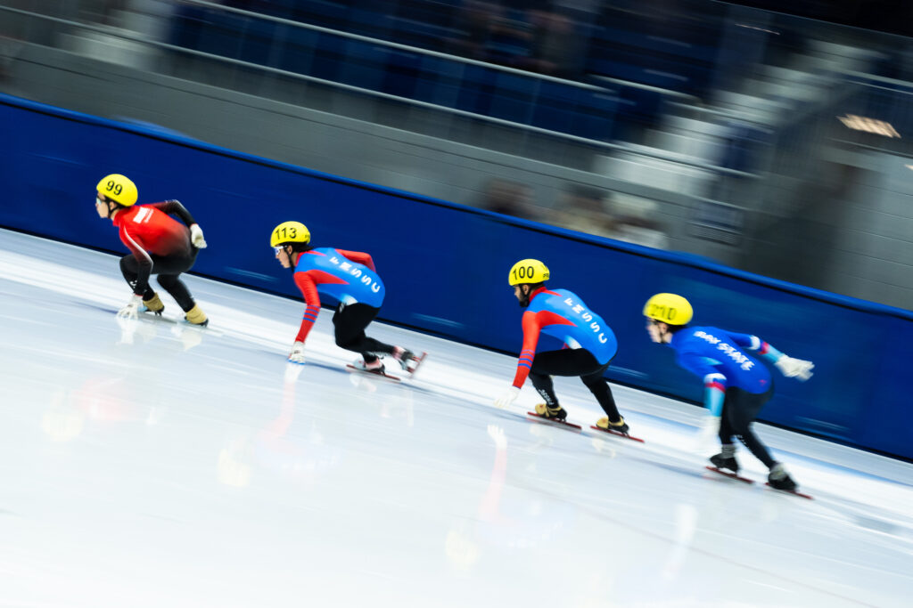 A group of athletes skating with helmet on the rink