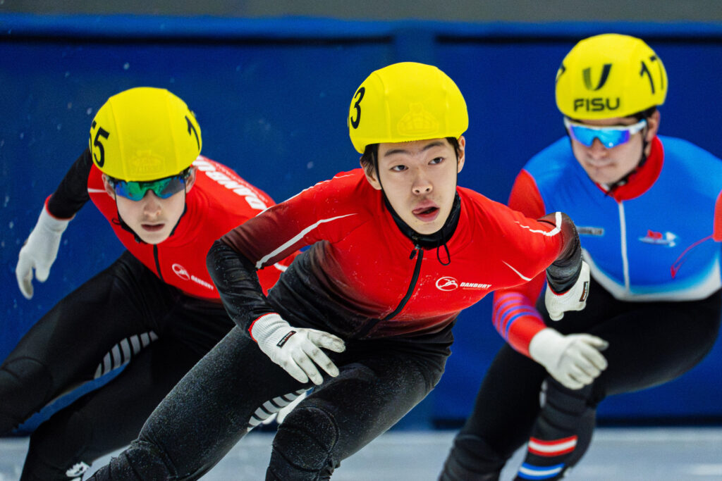 Two athletes skating with helmet on the rink