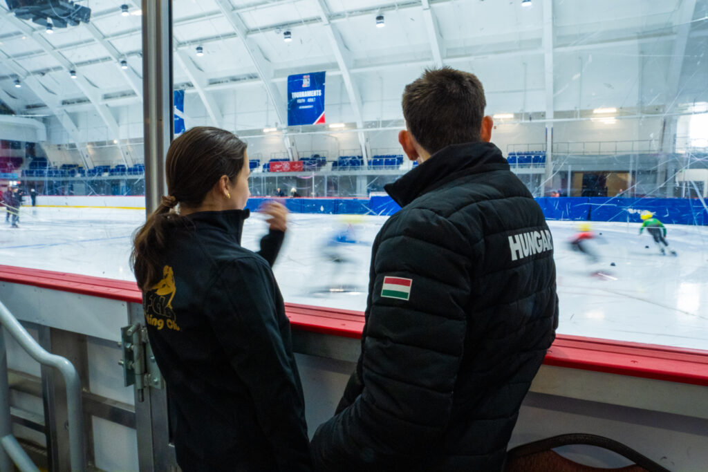 A group of athletes skating with helmet on the rink