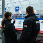 A group of athletes skating with helmet on the rink