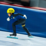 An athlete skating with helmet on the rink