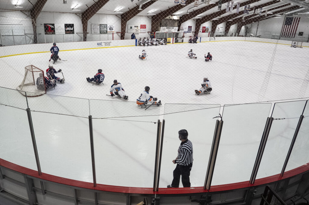 A group of athletes competing field hockey with helmet