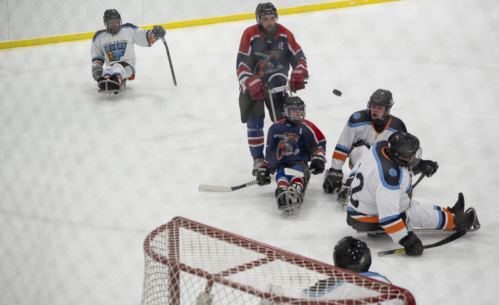 A group of athletes competing field hockey with helmet