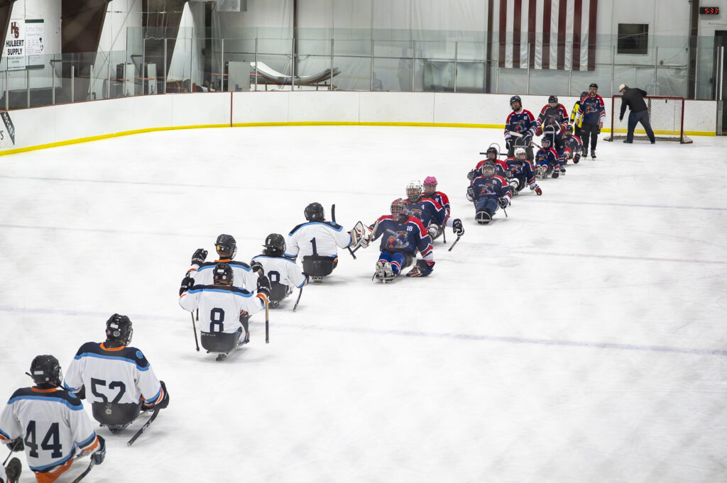 A group of athletes competing field hockey with helmet