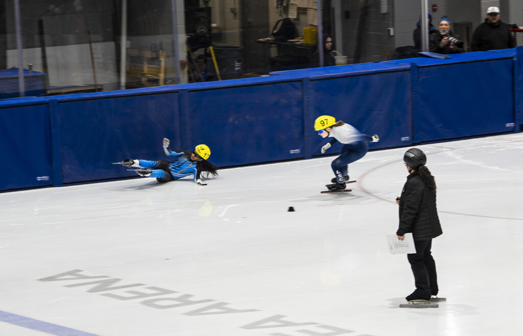 A group of athletes skating with helmet on the rink