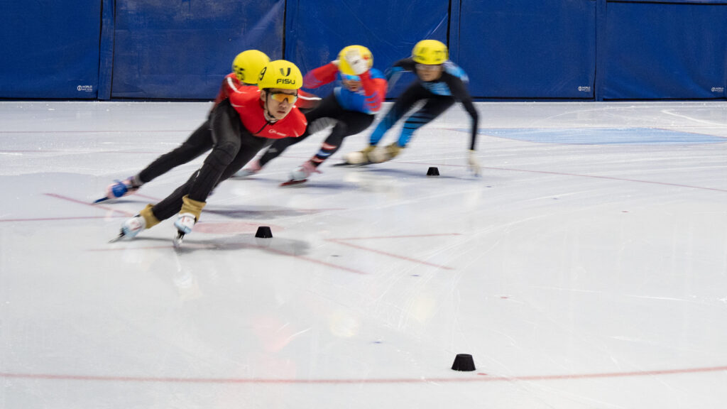 A group of athletes skating with helmet on the rink
