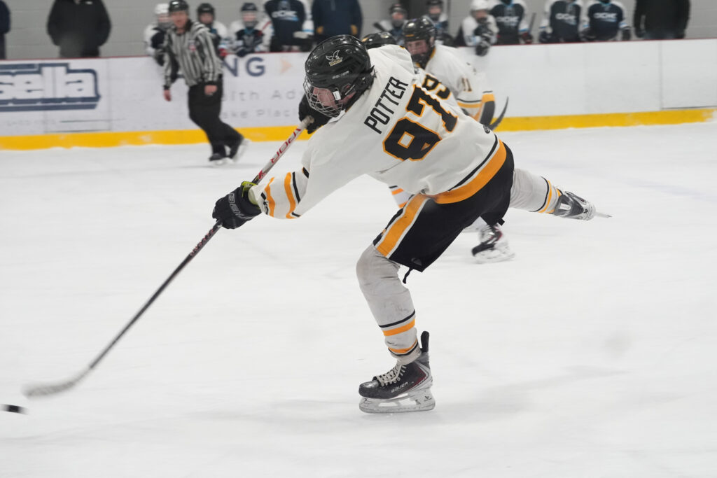 A group of athletes competing field hockey with helmet