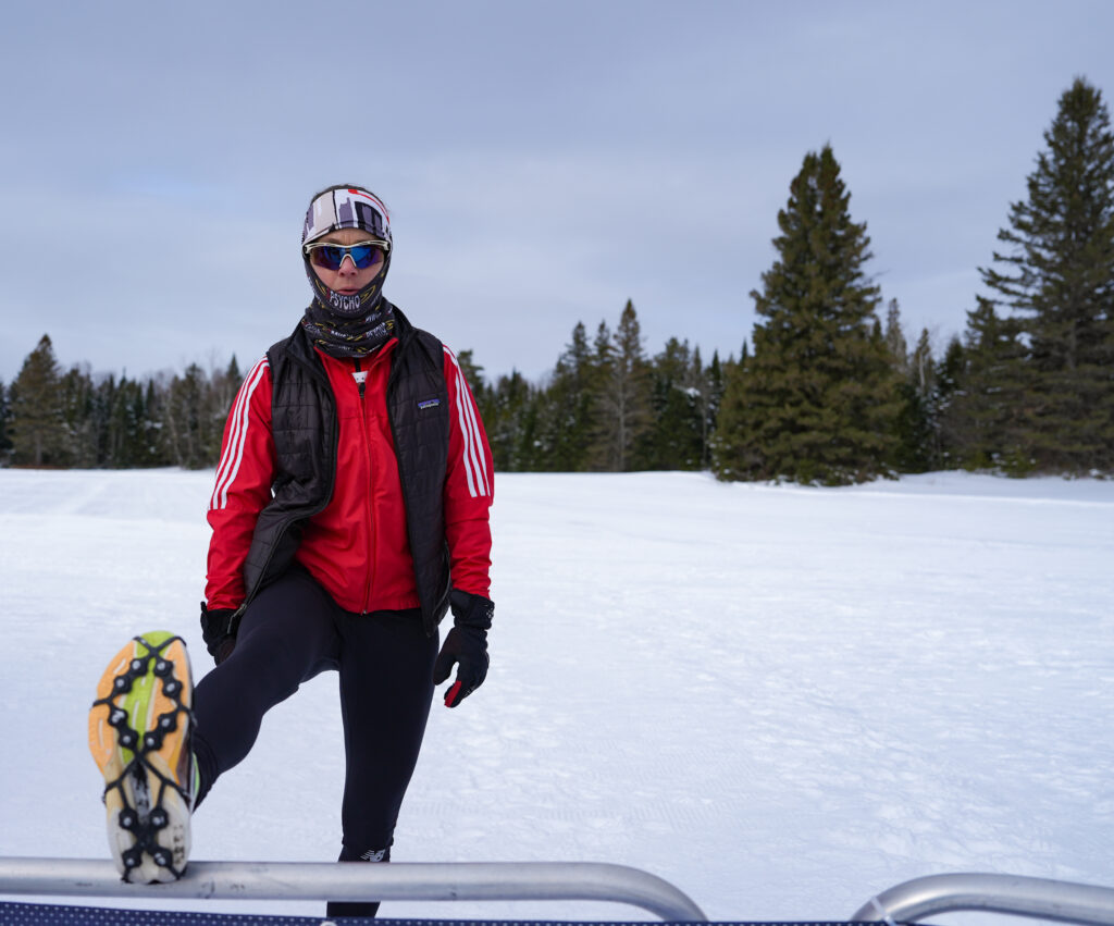 An athlete playing soccer with ball and helmet in the snow