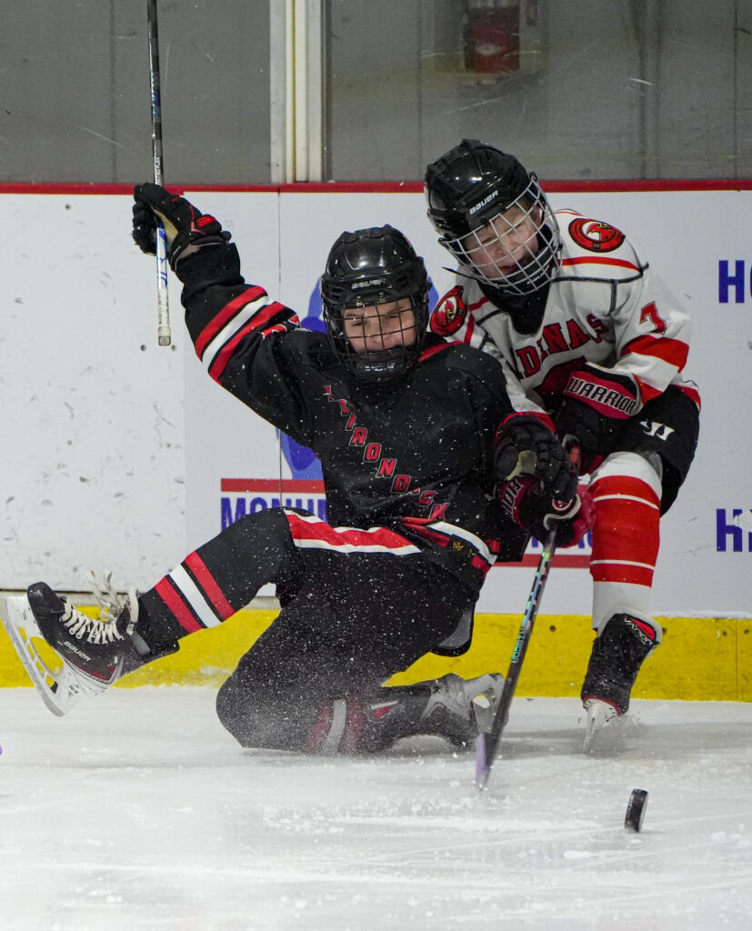 Two athletes skating with helmet on the rink