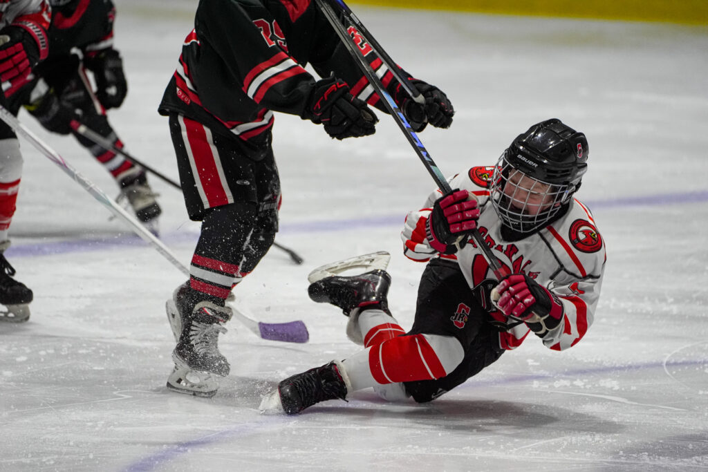 A group of athletes competing field hockey with helmet