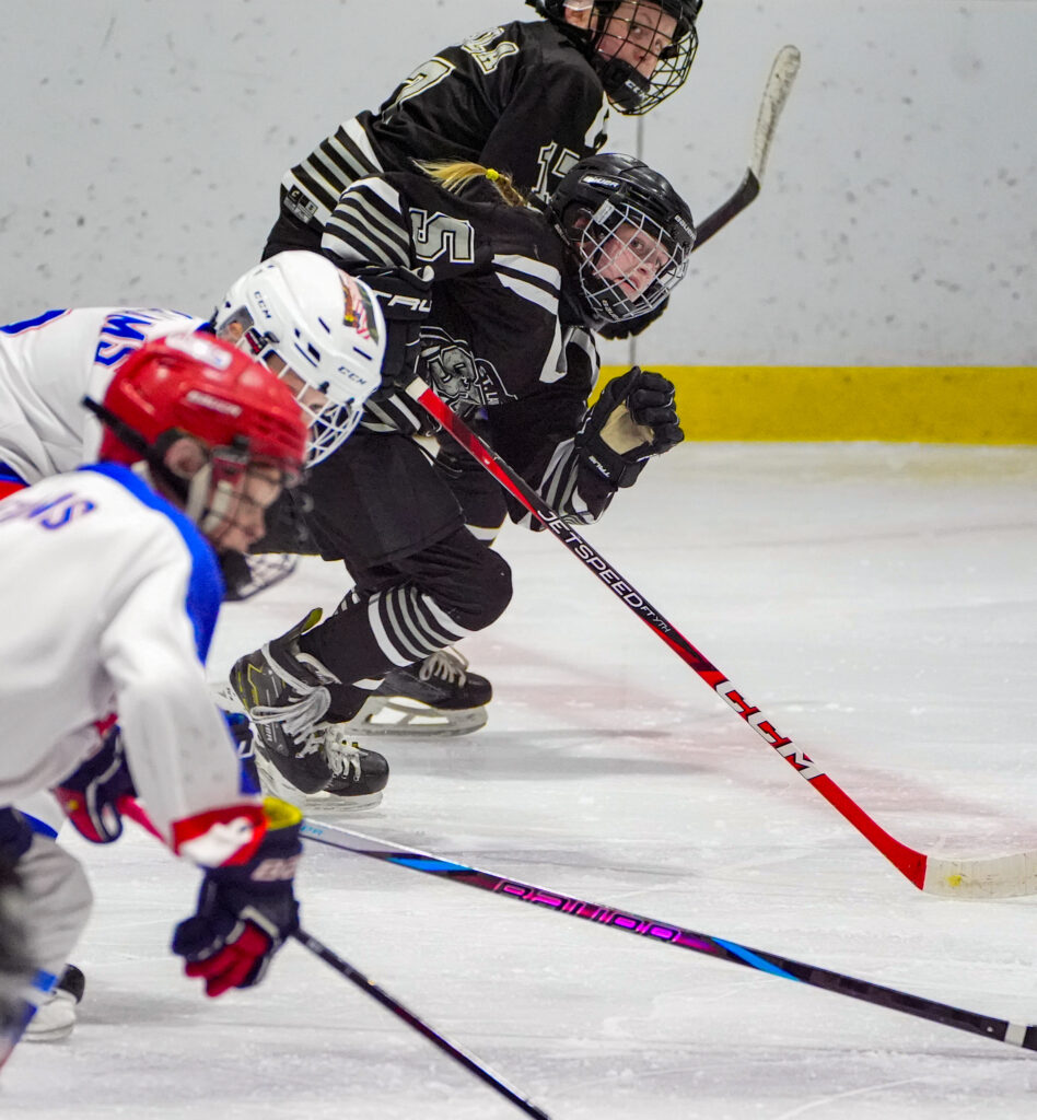 Two athletes competing field hockey with helmet